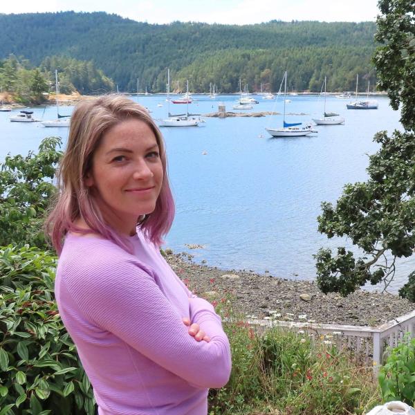 Woman in purple shirt in front of ocean